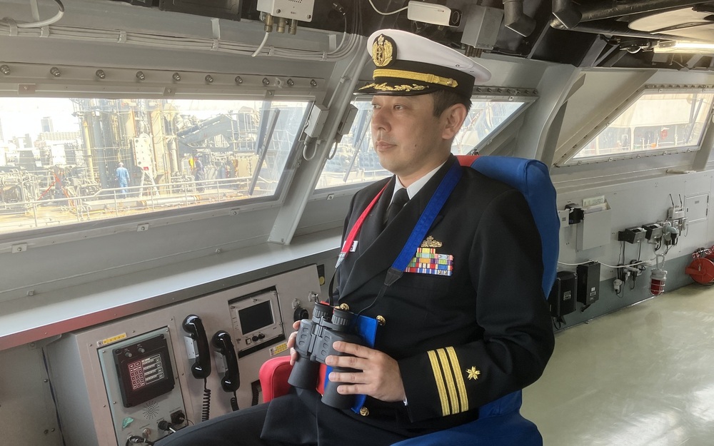前職の護衛艦「くまの」の岸壁前(上)と艦長席に座る泉2佐(提供:海上自衛隊)