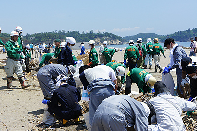 海岸沿いに残る流木等を撤去する防災士