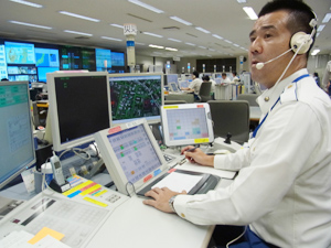 佐藤主任の席は電話対応する12名の後方に位置。常に通報される情報をシステム画面と音声で 把握、状況に応じて助言を行う
