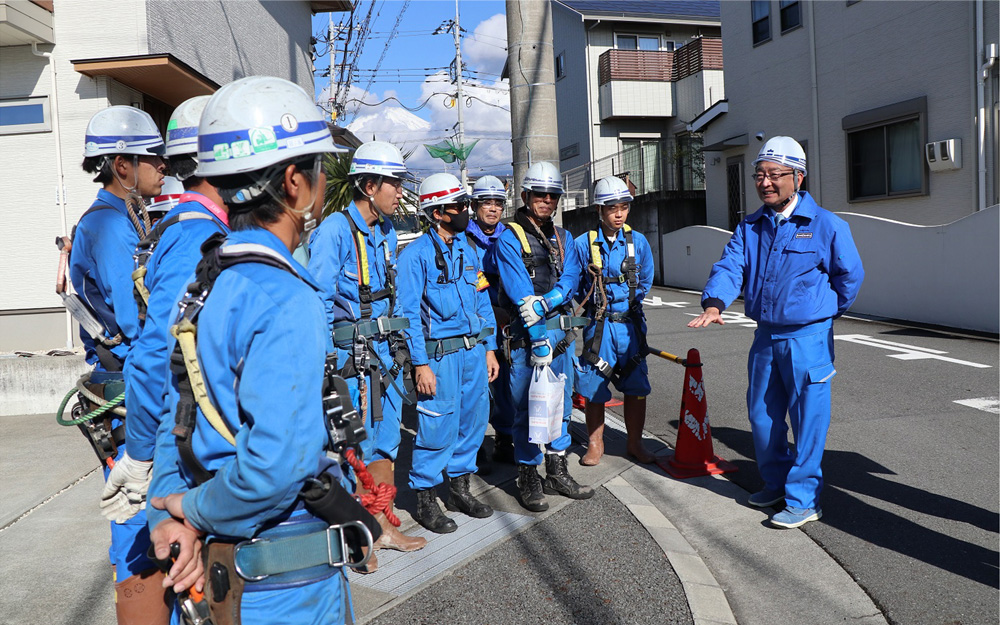 架空配電線現場で激励をする仲摩社長右）